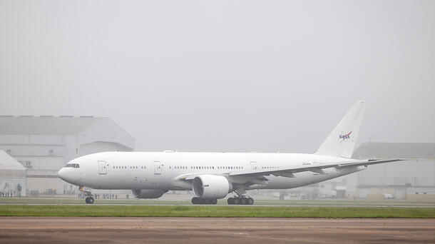 777 aircraft with NASA logo on tail lands at airport