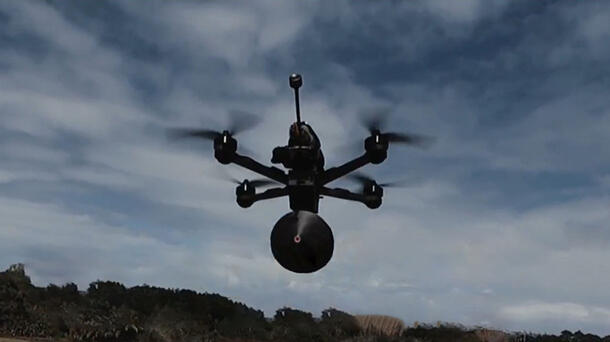 Flying drone with fiber-optic-tether
