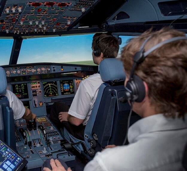 examiner monitoring pilots in simulator