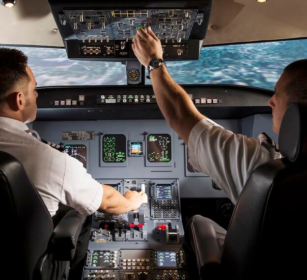 two pilots inside fixed based flight training device