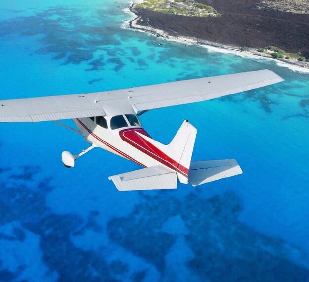 Sea plane flying over island