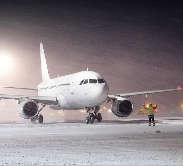 Commercial aircraft navigating the airfield during a snowstorm
