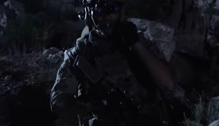 Warfighter walks through battlefield