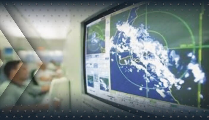 A computer monitor displays weather radar