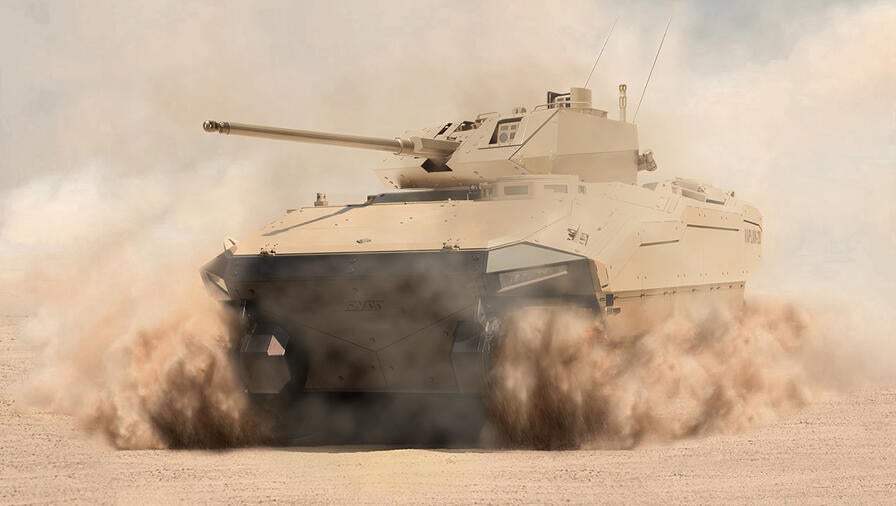 Armored vehicle in sand cloud kicked up from the tracks