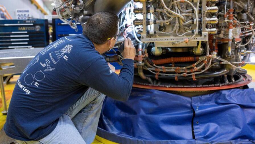 An Aerojet Rocketdyne engineer at its facility located at NASA’s Stennis Space Center examines RS-25 engine
