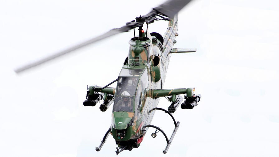 helicopter in flight nose down looking into cockpit with clear view of pilot
