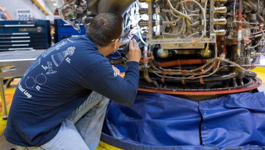 An Aerojet Rocketdyne engineer at its facility located at NASA’s Stennis Space Center examines RS-25 engine