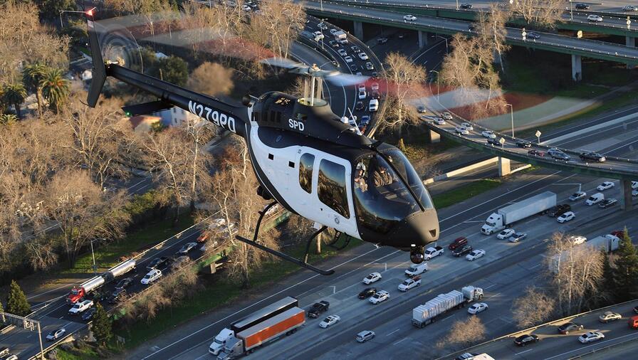 WESCAM MX-10 Mounted on Bell 505 Helicopter shown in flight above a city freeway