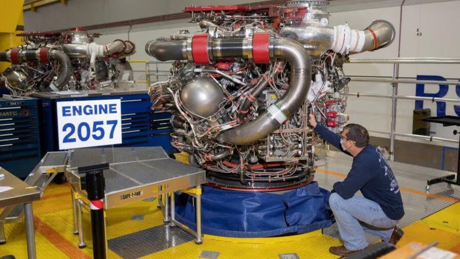 An Aerojet Rocketdyne engineer examines RS-25 engine