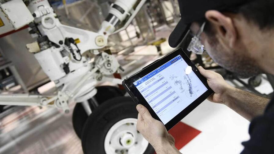 airplane hangar, L3Harris employee with tablet