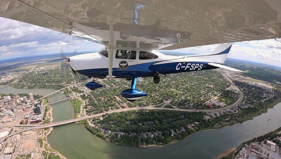 WESCAM MX-10 mounted on a Cessna 172. The image is taken flying above a stream and forested landscape capture from the underwing.