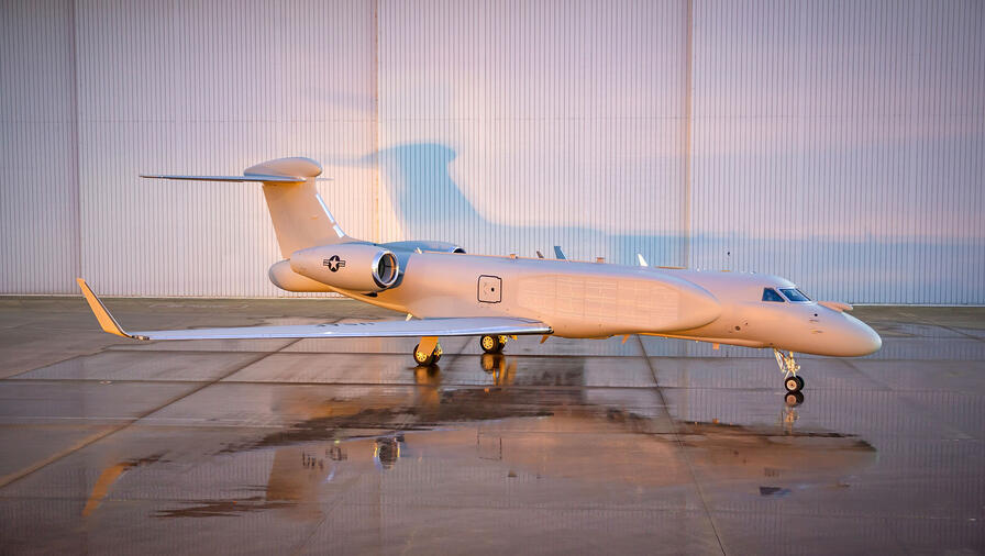EA-37B Compass Call aircraft parked outside of hangar