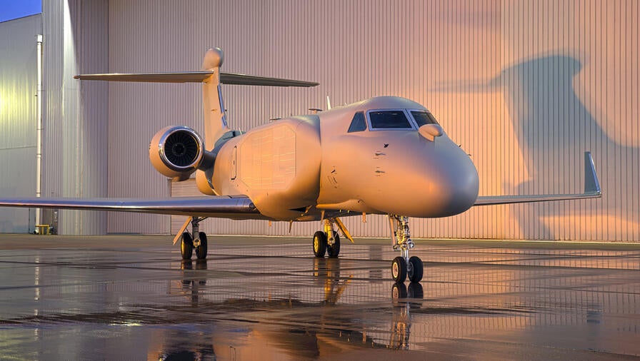 EA-37B Compass Call aircraft parked outside of hangar