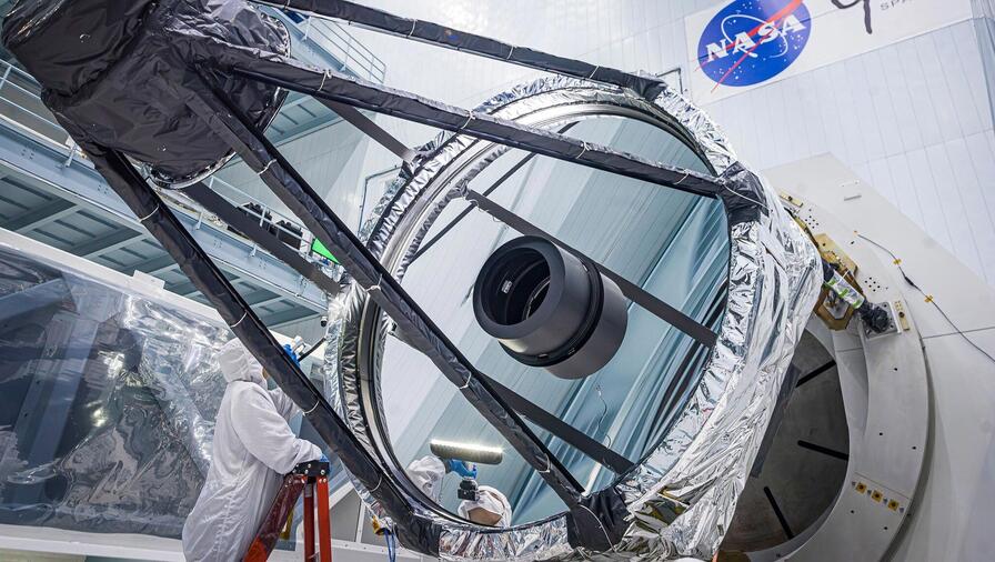 Optical Engineer Bente Eegholm performs an inspection of Roman's Primary mirror. This was taken shortly after it was lifted out of the shipping container.